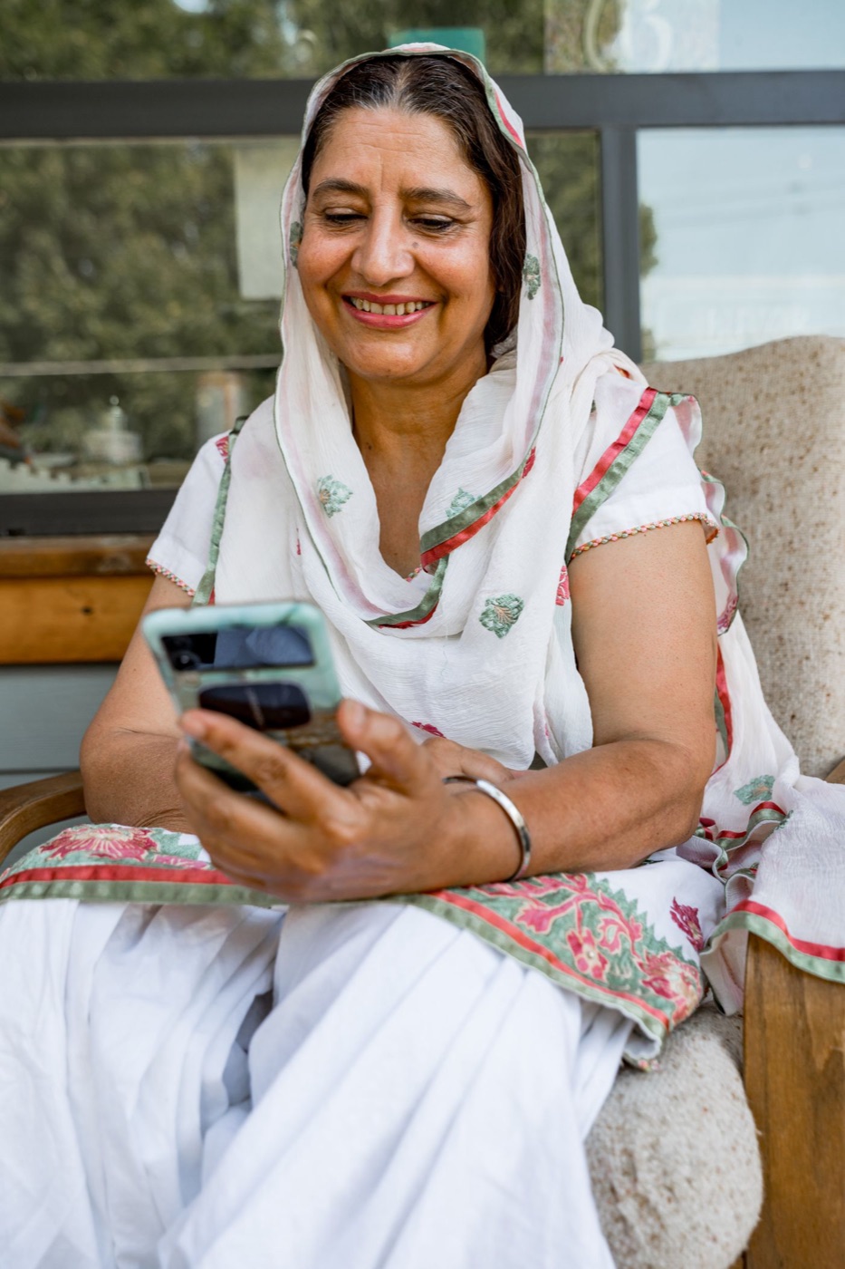An Indian grandmother smiling on a video call with her family